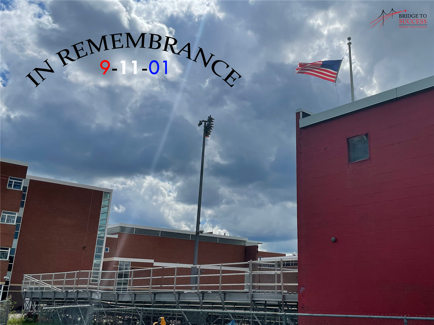 A photograph with Chelsea High School in the background and the American flag at Veterans Stadium in the foreground. 