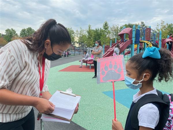 A student met with a teacher outside at the Mary C. Burke Elementary Complex, prior to the first day of school. 